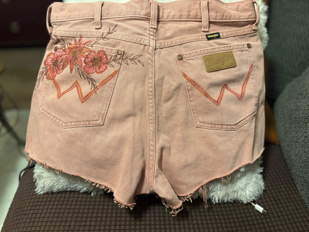 Back view of Wrangler dusty rose denim shorts with floral fabric paint detail