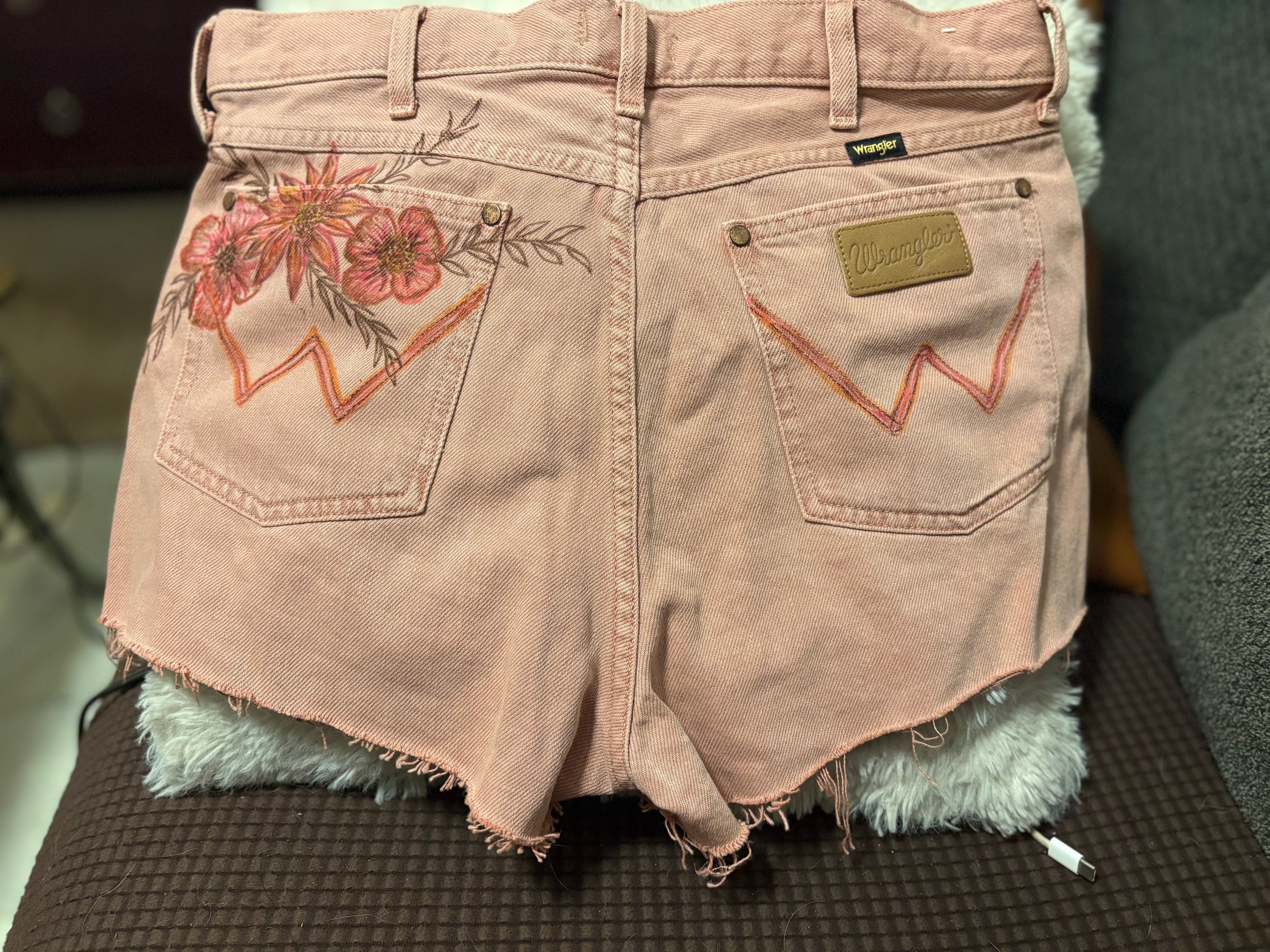 Back view of Wrangler dusty rose denim shorts with floral fabric paint detail