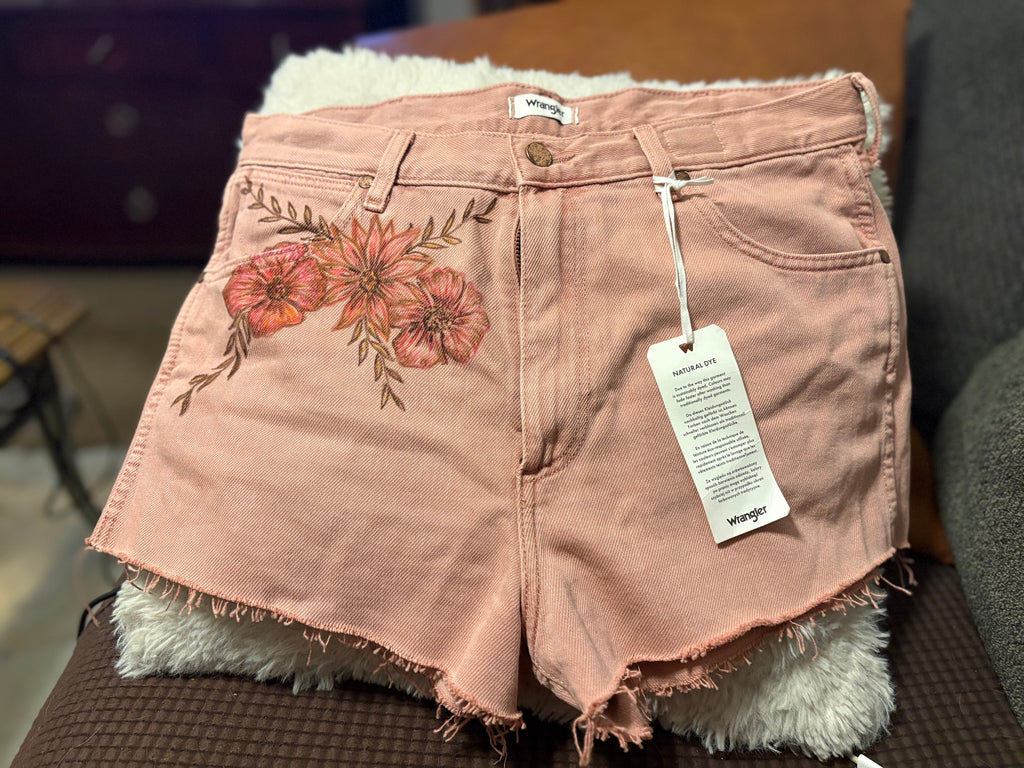 Front view of Wrangler dusty rose denim shorts with floral fabric paint detail