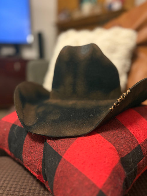 Midnight Forest pyrography cowboy hat — side profile view on buffalo plaid fabric