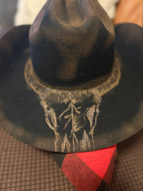 Close-up of hand-burned forest pyrography design on the brim of the cowboy hat
