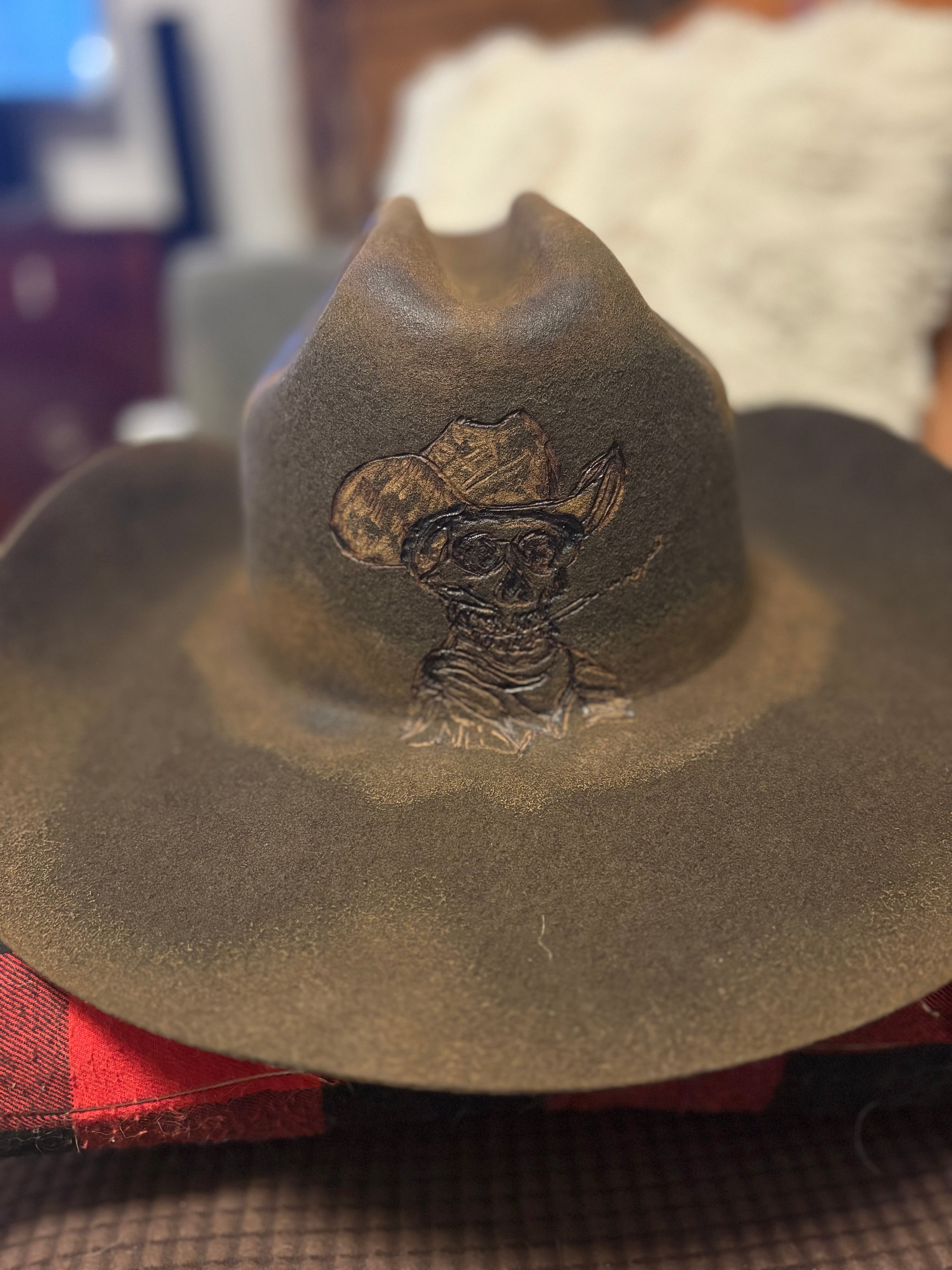 Dark olive felt cowboy hat with gold chain-stitch brim detailing, side view